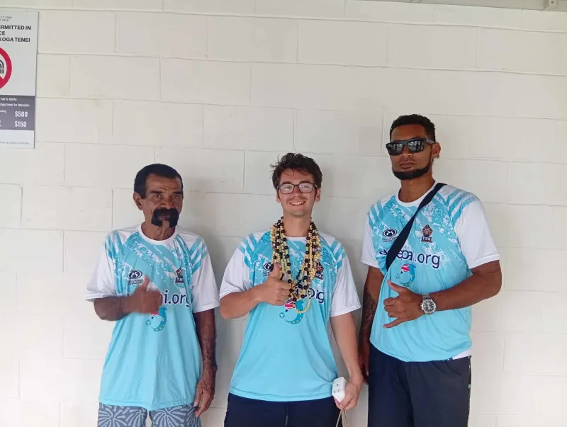 Nick Miller with Tuvaluan football community members in matching team shirts.